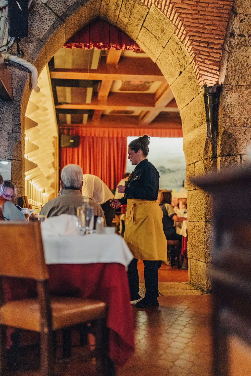 L'arco di pietra e i tendaggi rossi della sala del Café Luso