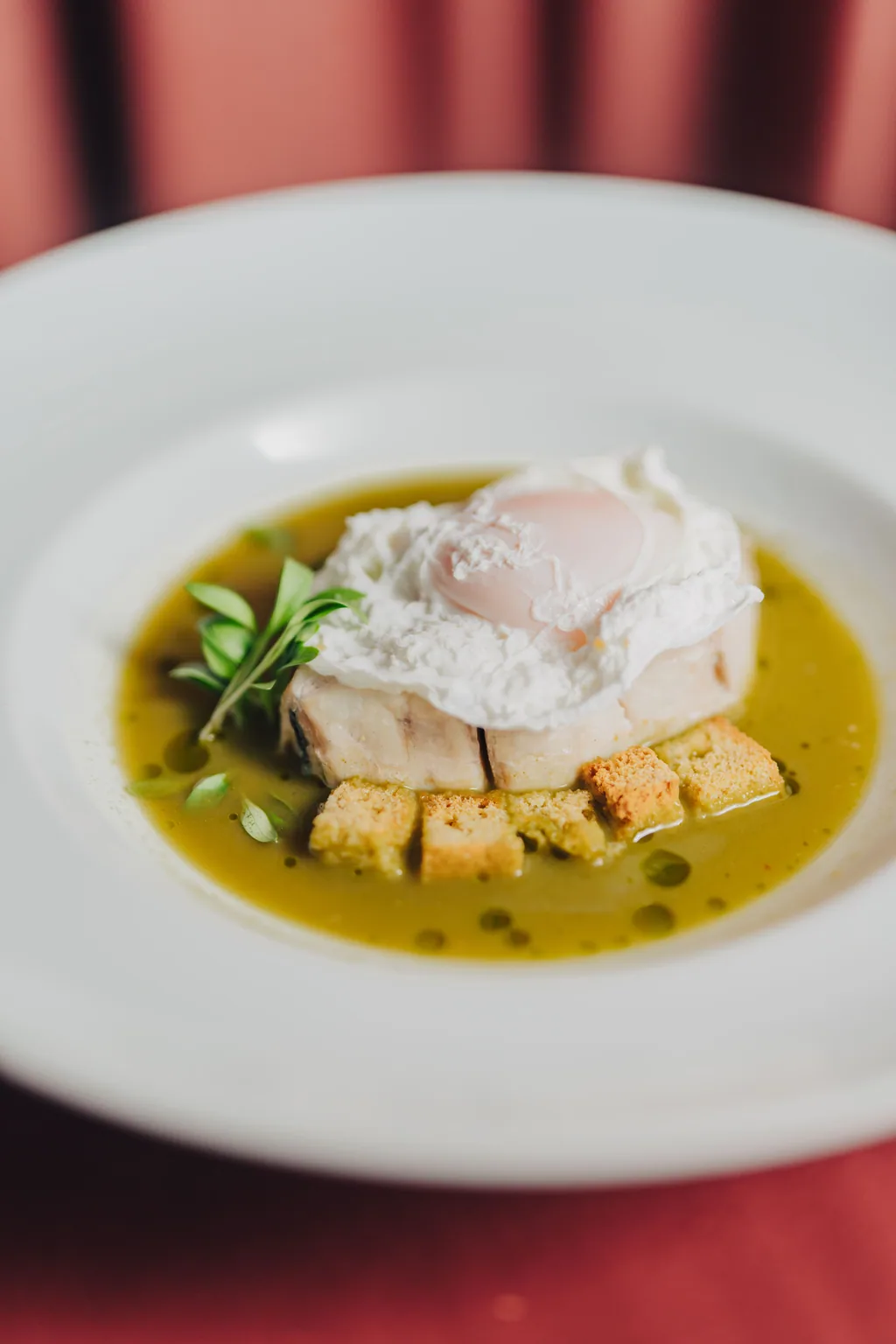 Prato de peixe com ovo escalfado e croutons