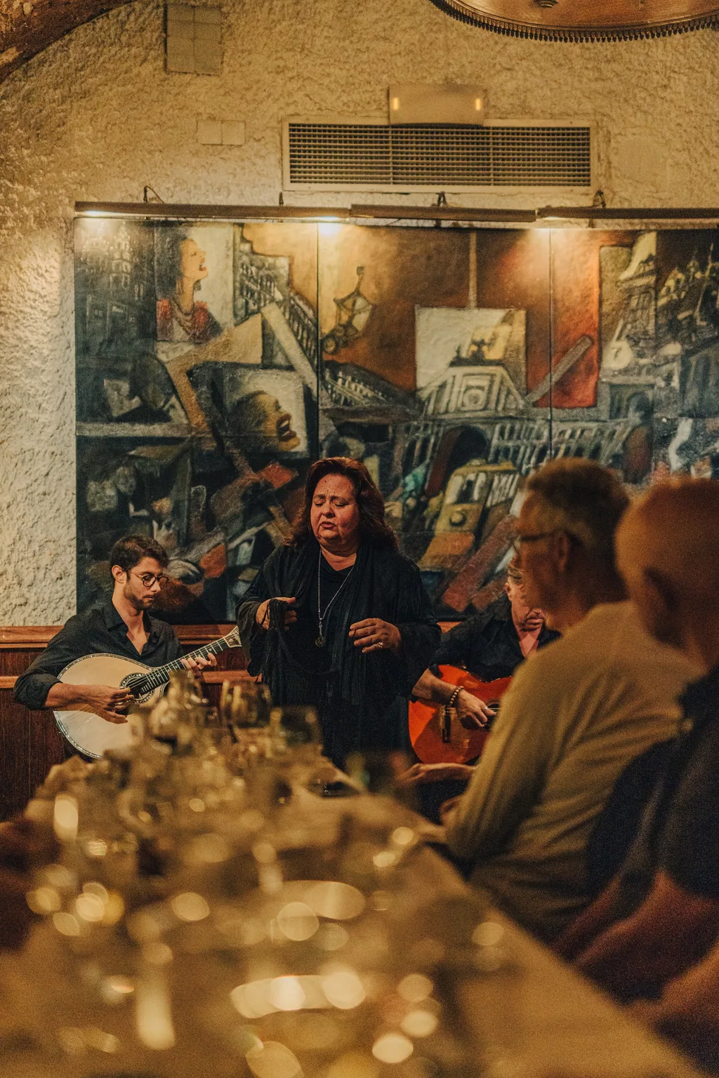 A mesa comprida em primeiro plano e o fado ao fundo