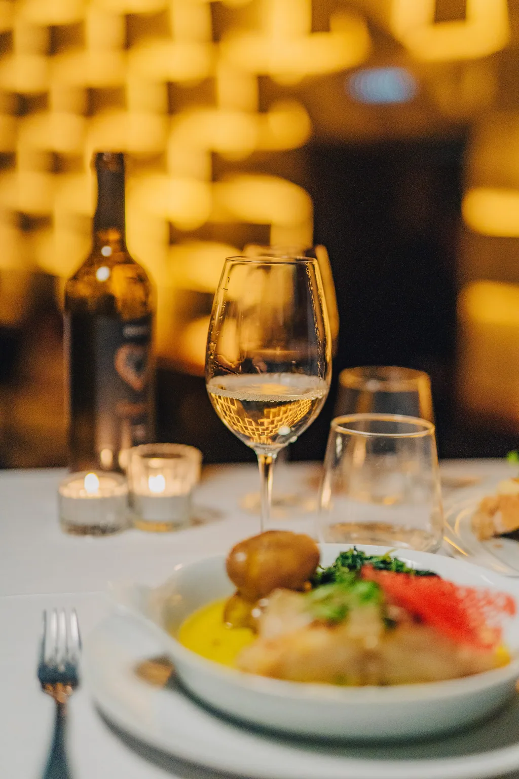 Teller, Wein und Kerzen auf demselben Tisch