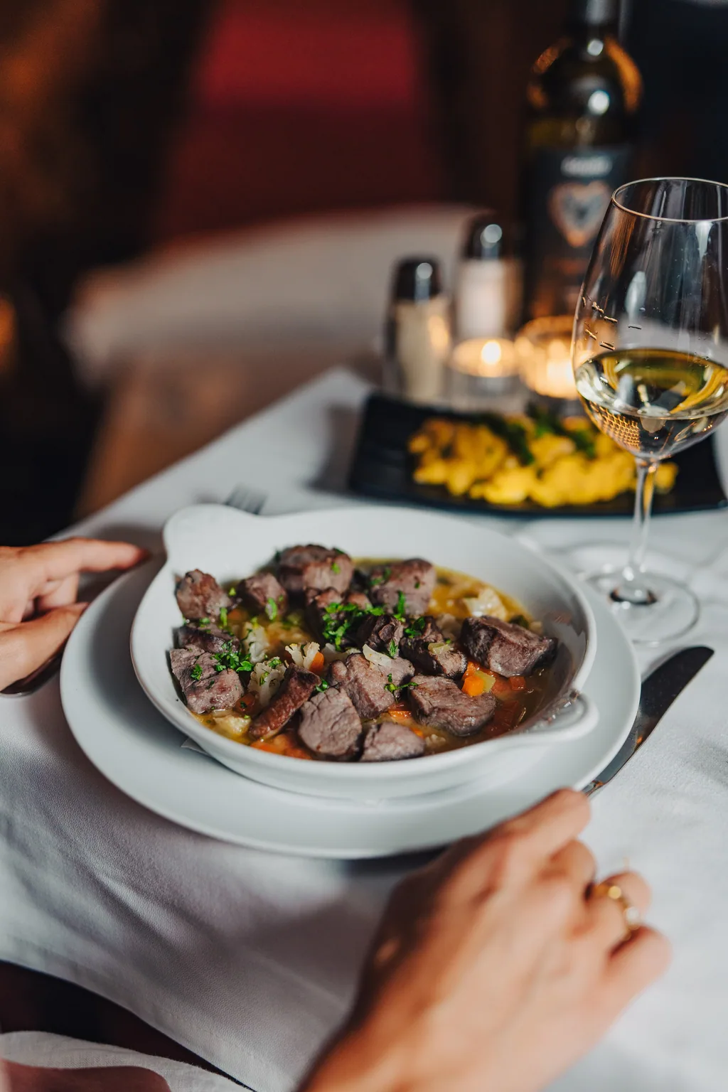 Geschmortes Fleisch am Tisch, zwischen den Kerzen